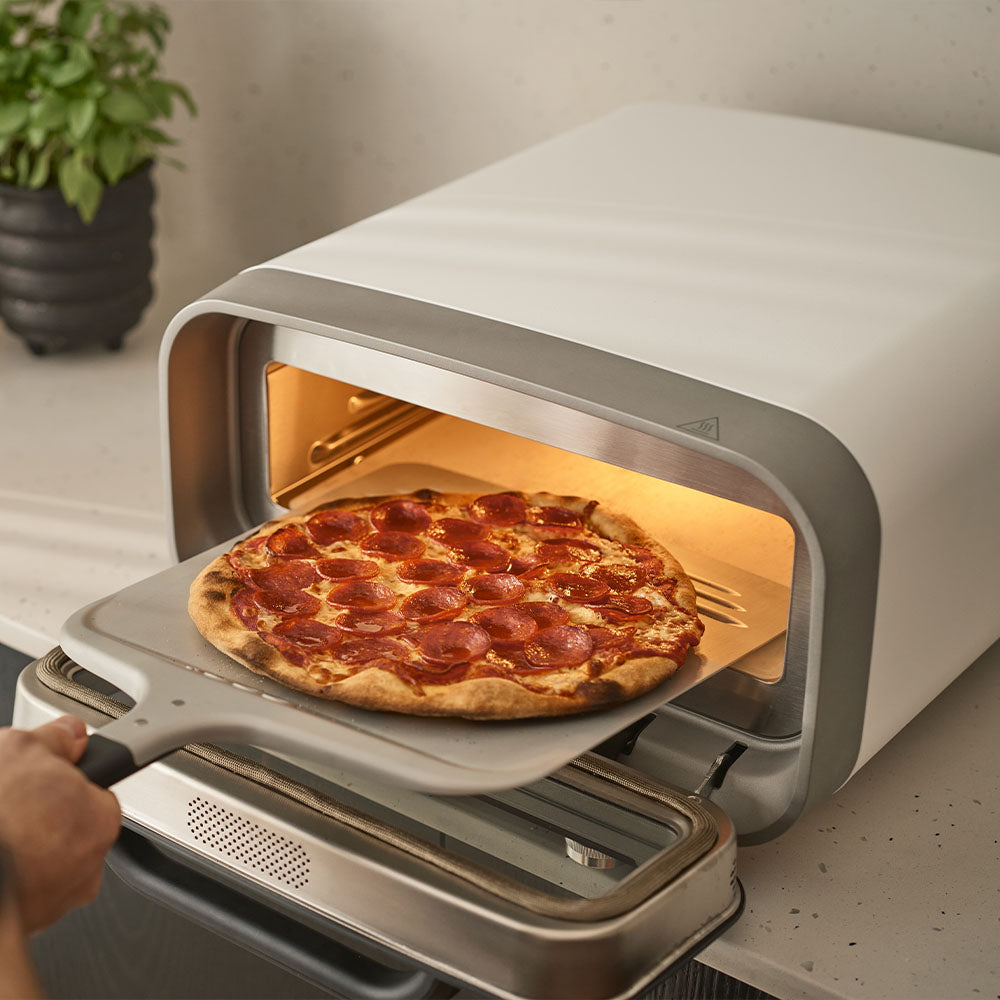 Une pizza pepperoni sortie du Ooni Volt 2 sur une pelle